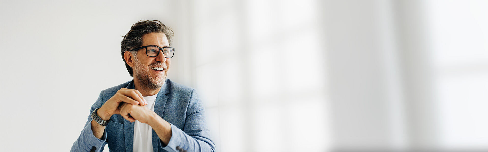 ein Mann in einer blauen Jacke und Brille