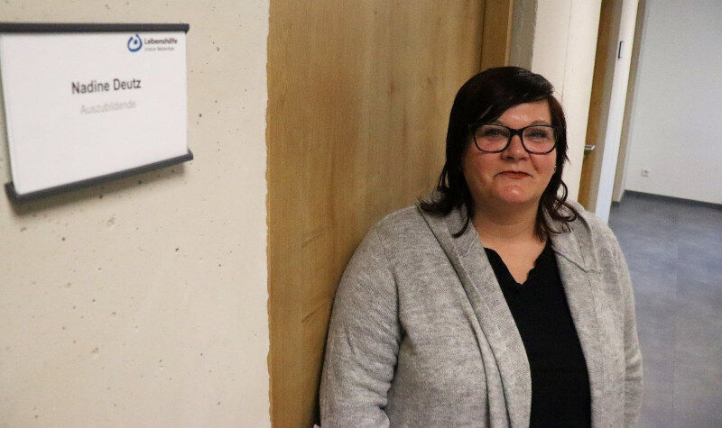 eine Frau, die vor einer Wand steht