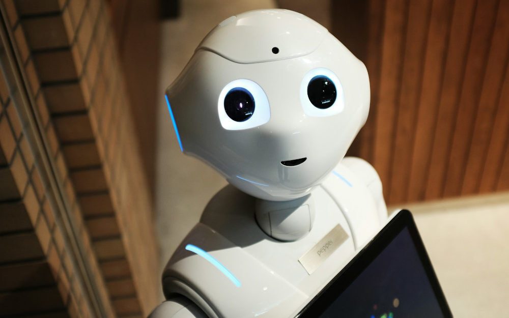 Ein niedlicher, menschlich anmutender Roboter schaut fragend nach oben.