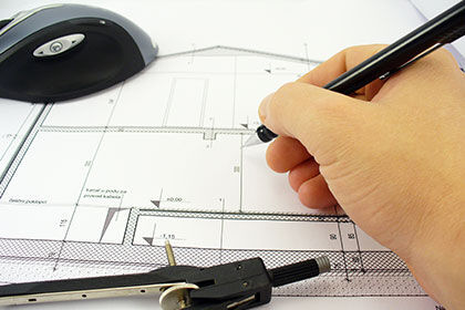 eine Person zeichnet einen Hausplan mit einem Bleistift