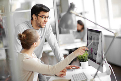 ein Mann und eine Frau, die an einem Schreibtisch arbeiten