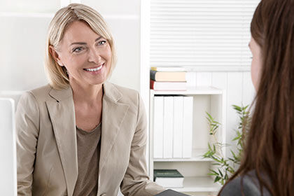 eine Frau sitzt an einem Schreibtisch mit einem Laptop
