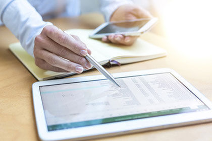 eine Person, die an einem Tisch mit einem Tablet sitzt